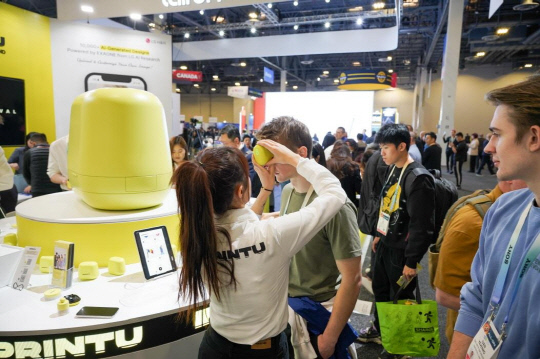 '2024 CES' 임프린투 부스를 방문한 한 관람객이 임프린투 기기로 자신의 얼굴에 타투를 그려 넣고 있다. LG생활건강 제공.